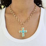 Large gold circle link chain with a toggle clasp and a large gold Cross with turquoise stones.