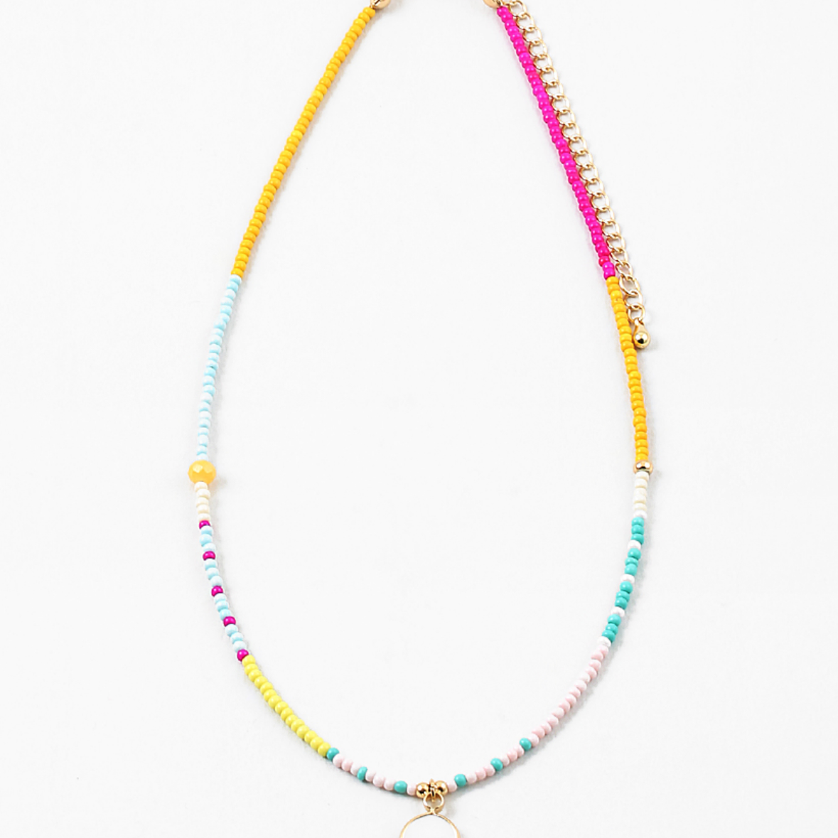 Small bead necklace in yellow, pink, turquoise and white beads. Necklace has a small white enamel disc pendant at its center.