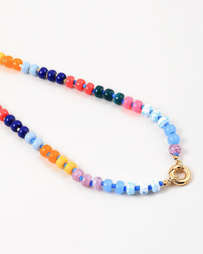Bead necklace made of navy, pink, orange, yellow and light blue beads. Center of the necklace has a large gold clasp.