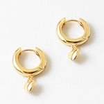 Gold hoop earrings with a small heart pendant on a white background