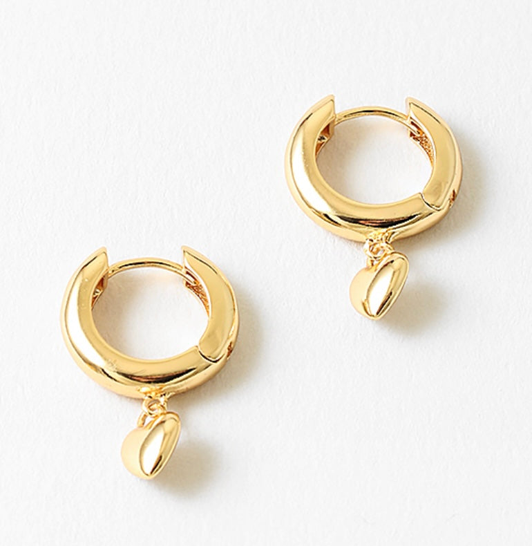 Gold hoop earrings with a small heart pendant on a white background