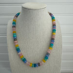 Picture of a necklace made of purple, blue, white, yellow and pink beads.
