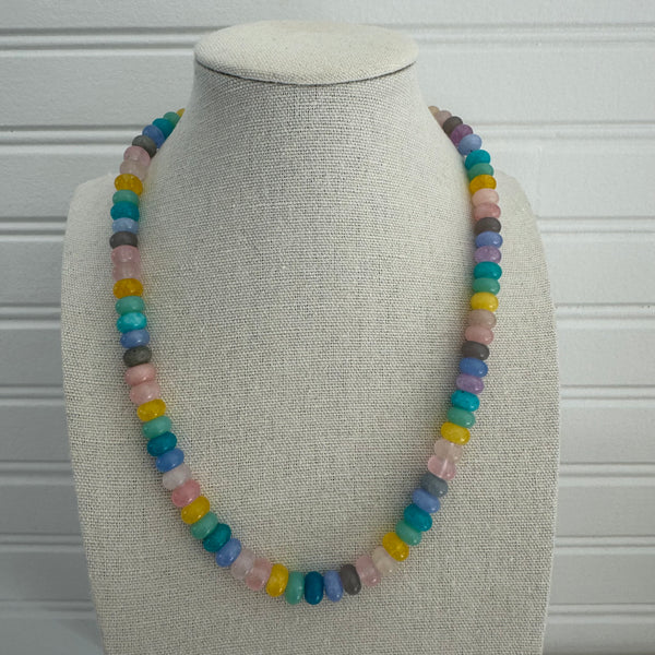 Picture of a necklace made of purple, blue, white, yellow and pink beads.