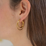 Picture of model wearing gold earrings made of three hoops.
