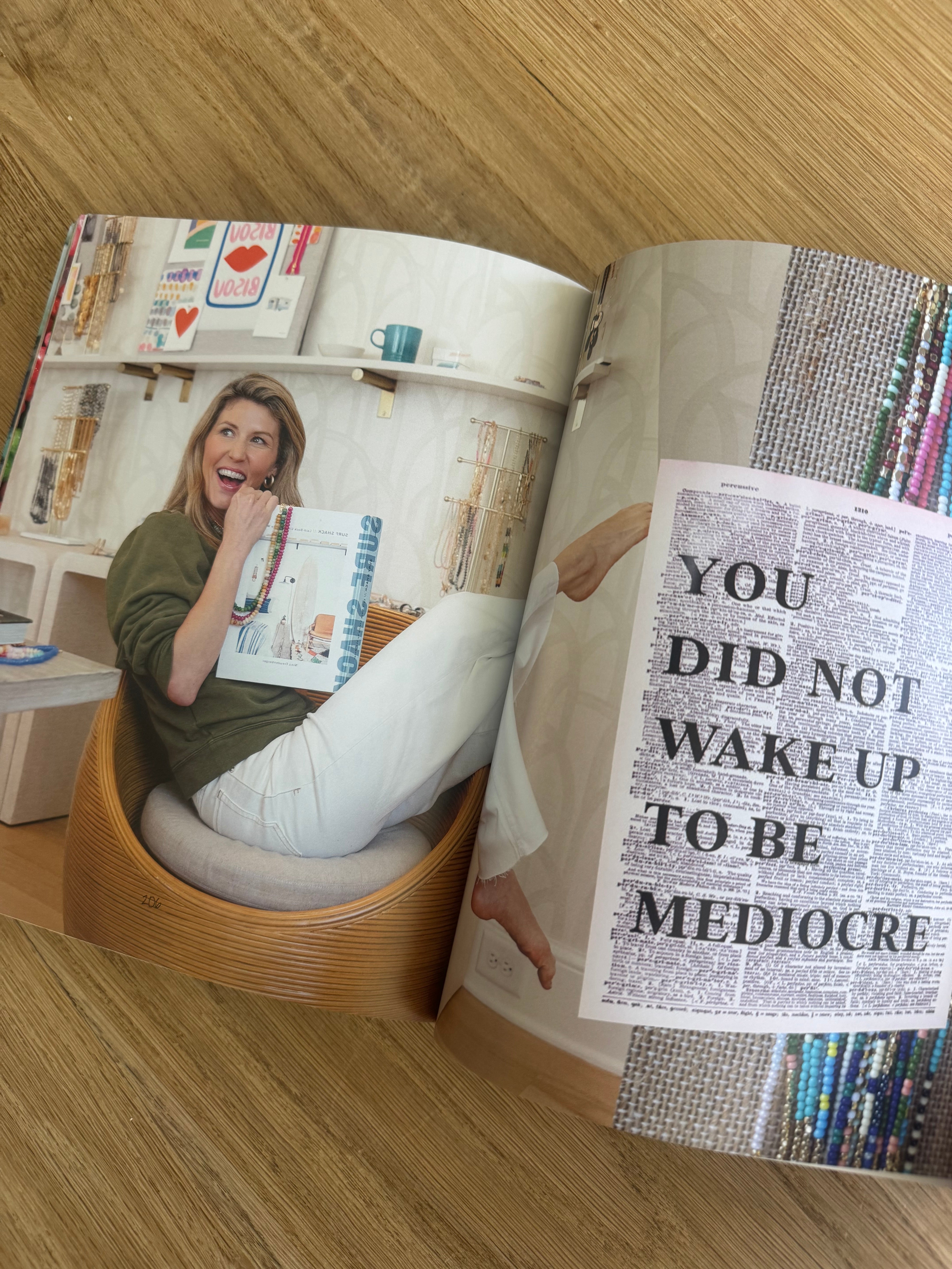 Open magazine with a woman on one page and text on the other, on a wooden surface.