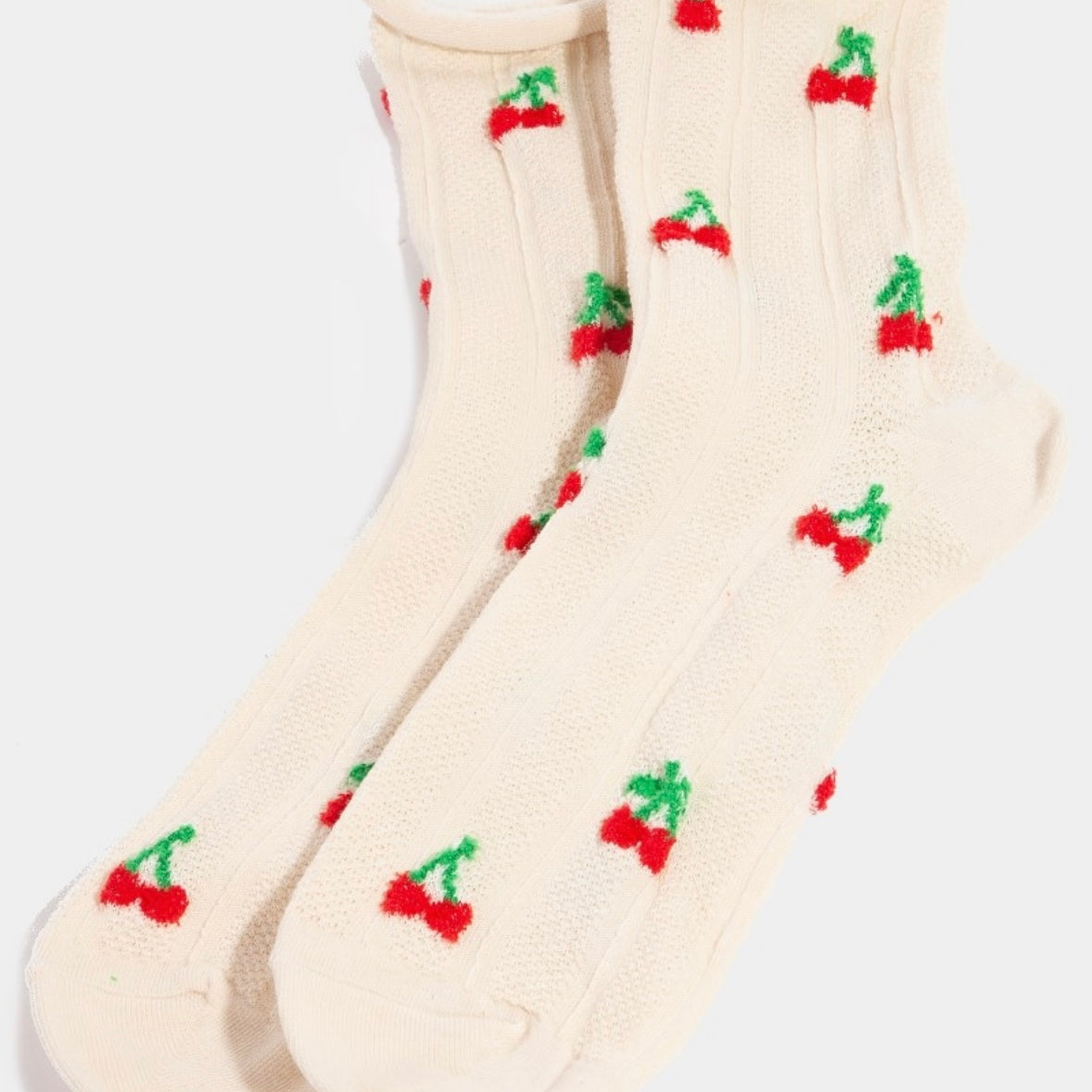 Picture of a pair of feminine white socks with small cherries all over them.