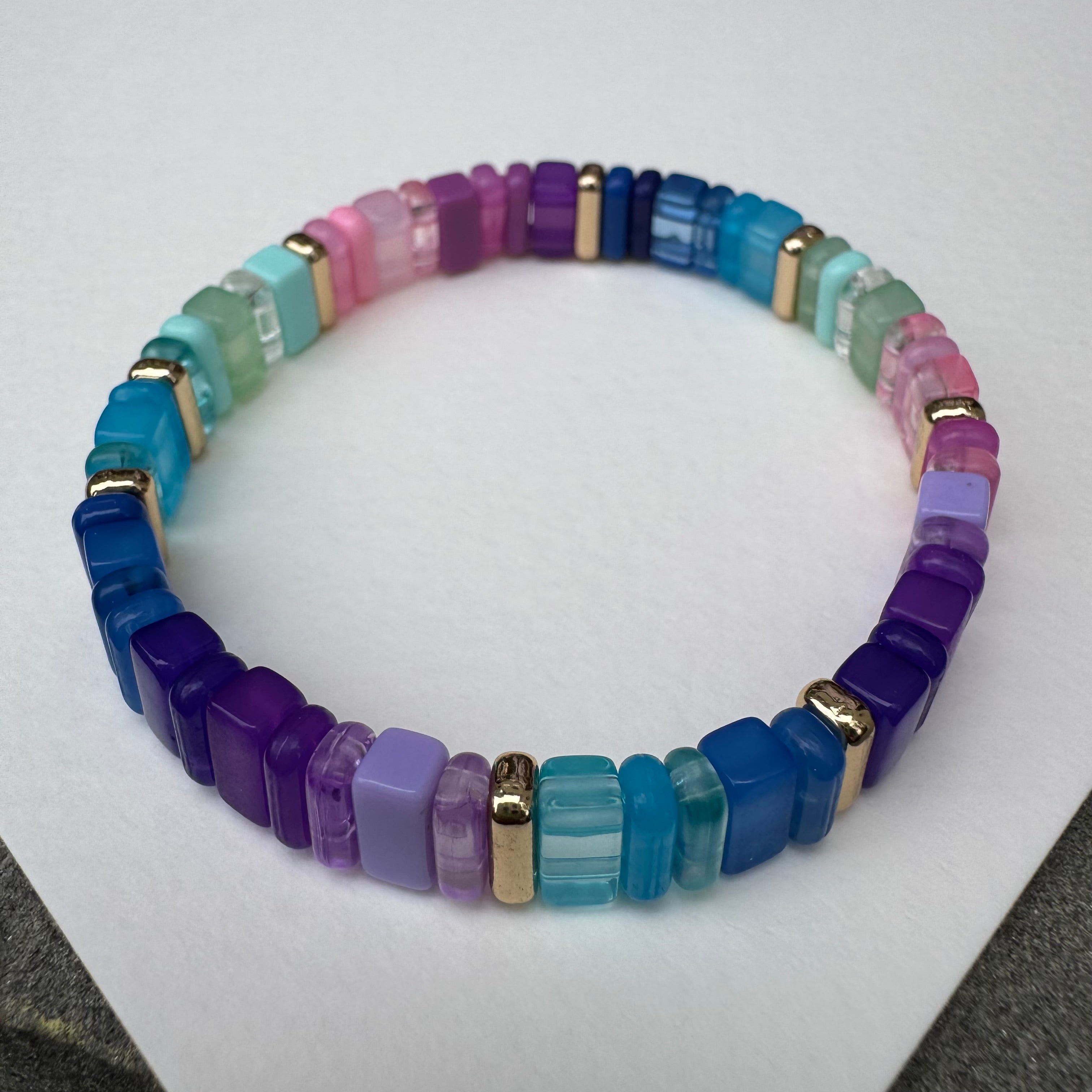 Picture of a multicolored bead bracelet in mostly purples, blues, green and pink.