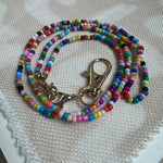 Picture of a multicolored beaded lanyard with a gold clasp.