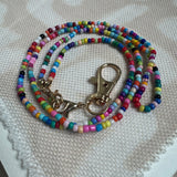 Picture of a multicolored beaded lanyard with a gold clasp.