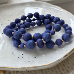 Blue beaded bracelets on a white speckled plate
