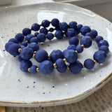 Blue beaded bracelets on a white speckled plate