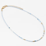 Dainty bead necklace with clear blue beads, gold and some solid blue beads.