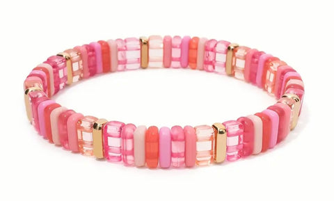 Bead bracelet in clear and solid pinks and Gold accent beads.