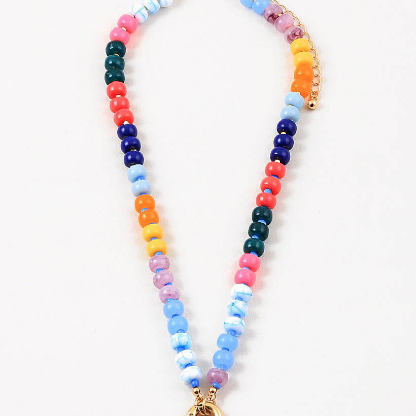Bead necklace made out of navy blue, orange, yellow, purple and blue beads. Necklace has a large gold clasp at its center.