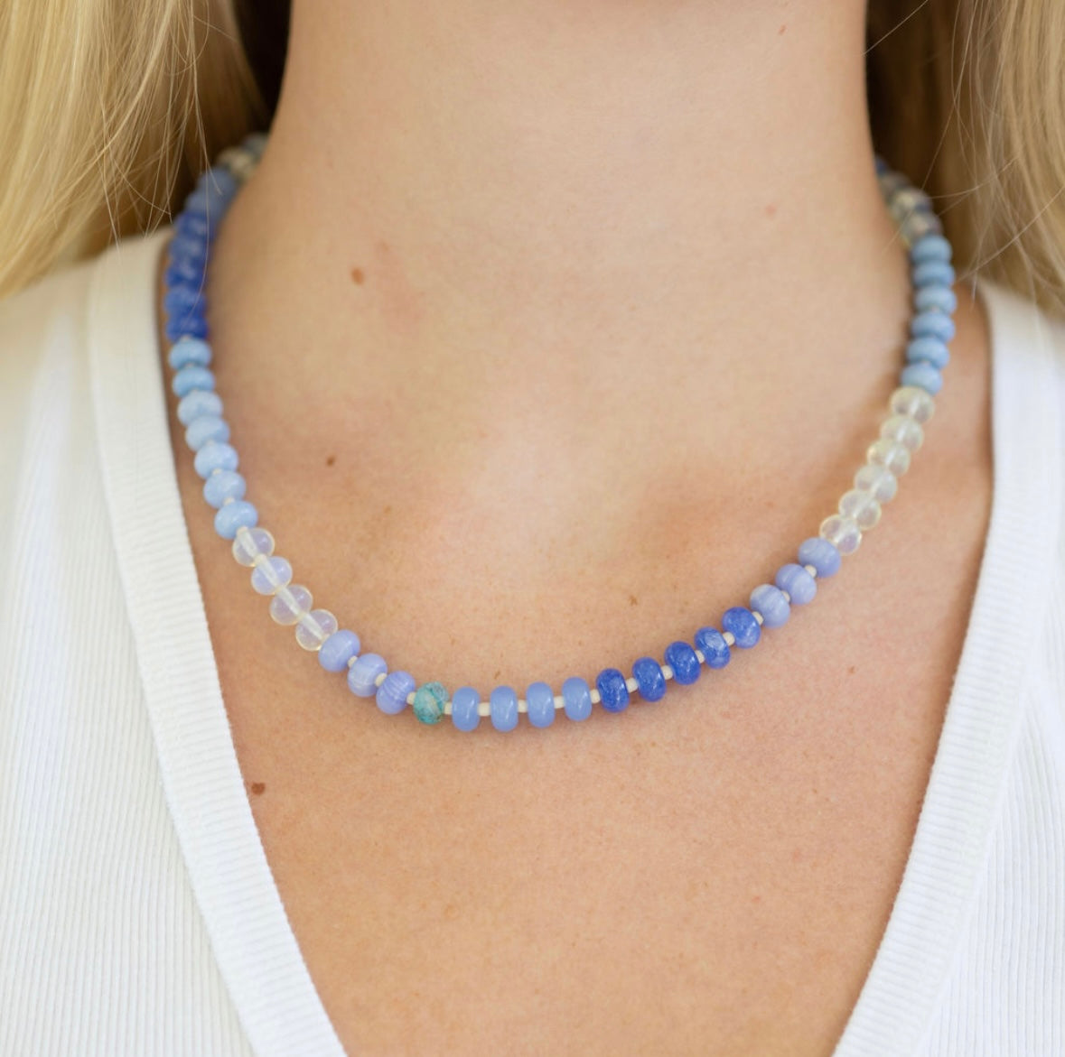 Necklace with blue and white beads worn by a person