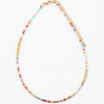 Colorful beaded necklace red, orange, gold and blue beads with gold chain on a white background