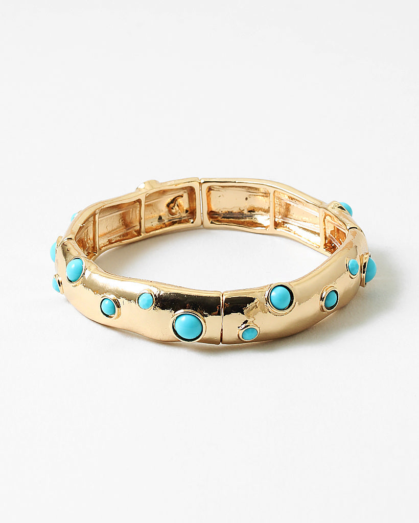 Gold cuff style bracelet with inlaid turquoise beads.