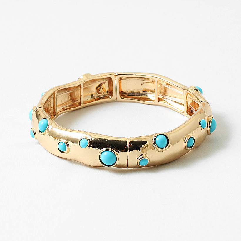 Gold cuff style bracelet with inlaid turquoise beads.