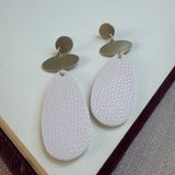 Gold and White dangle earrings. Earrings have a small gold circle base, a small oval and large white teardrop beads at the base.