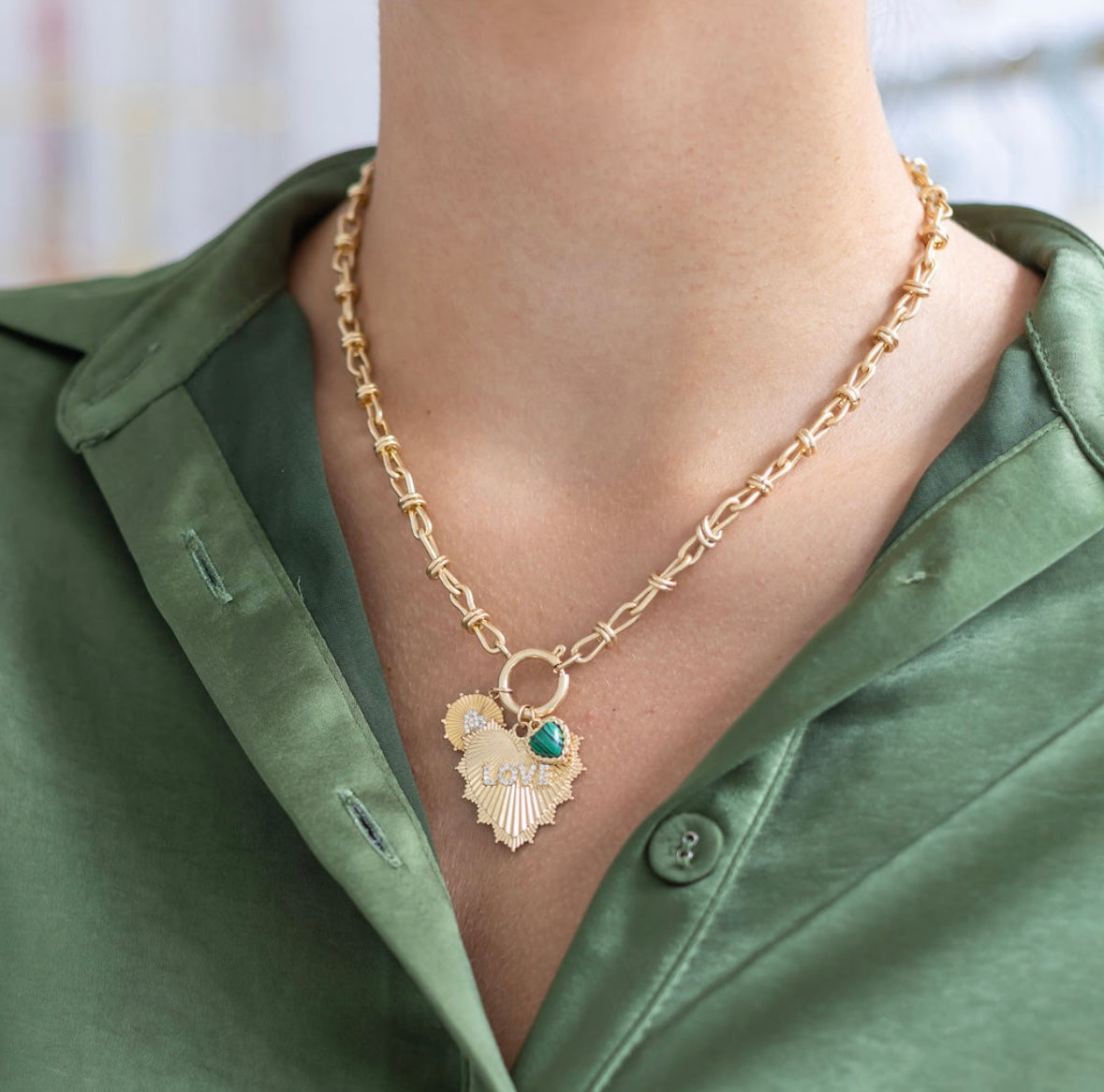 Woman wearing a gold heart toggle necklace