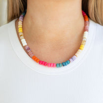 Colorful beaded necklace worn by a person on a white background