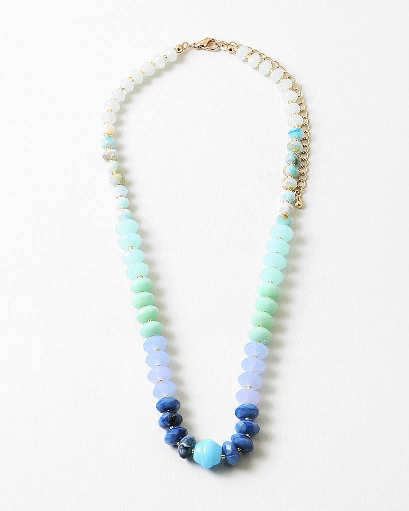 Necklace with blue and green beads on a white background