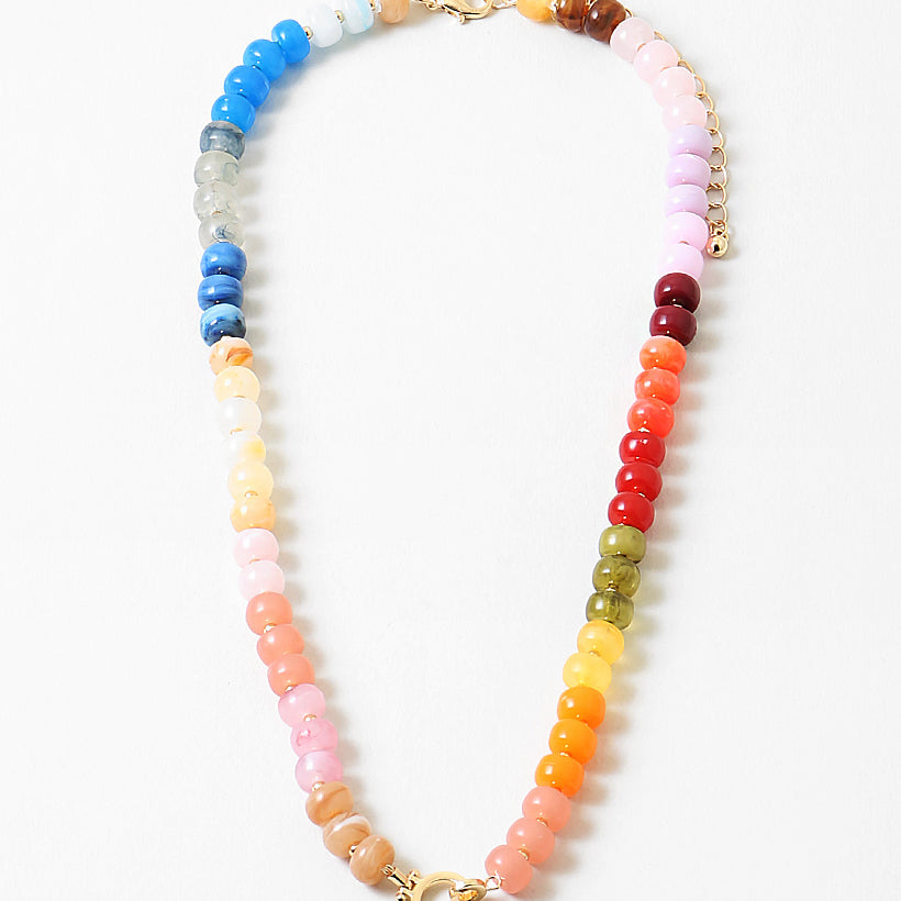Multicolor bead necklace in blues, reds, corals, yellows, greens, reds and pinks with a large toggle clasp at its center.