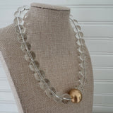 Chunky clear bead statement necklace with a large gold center bead.