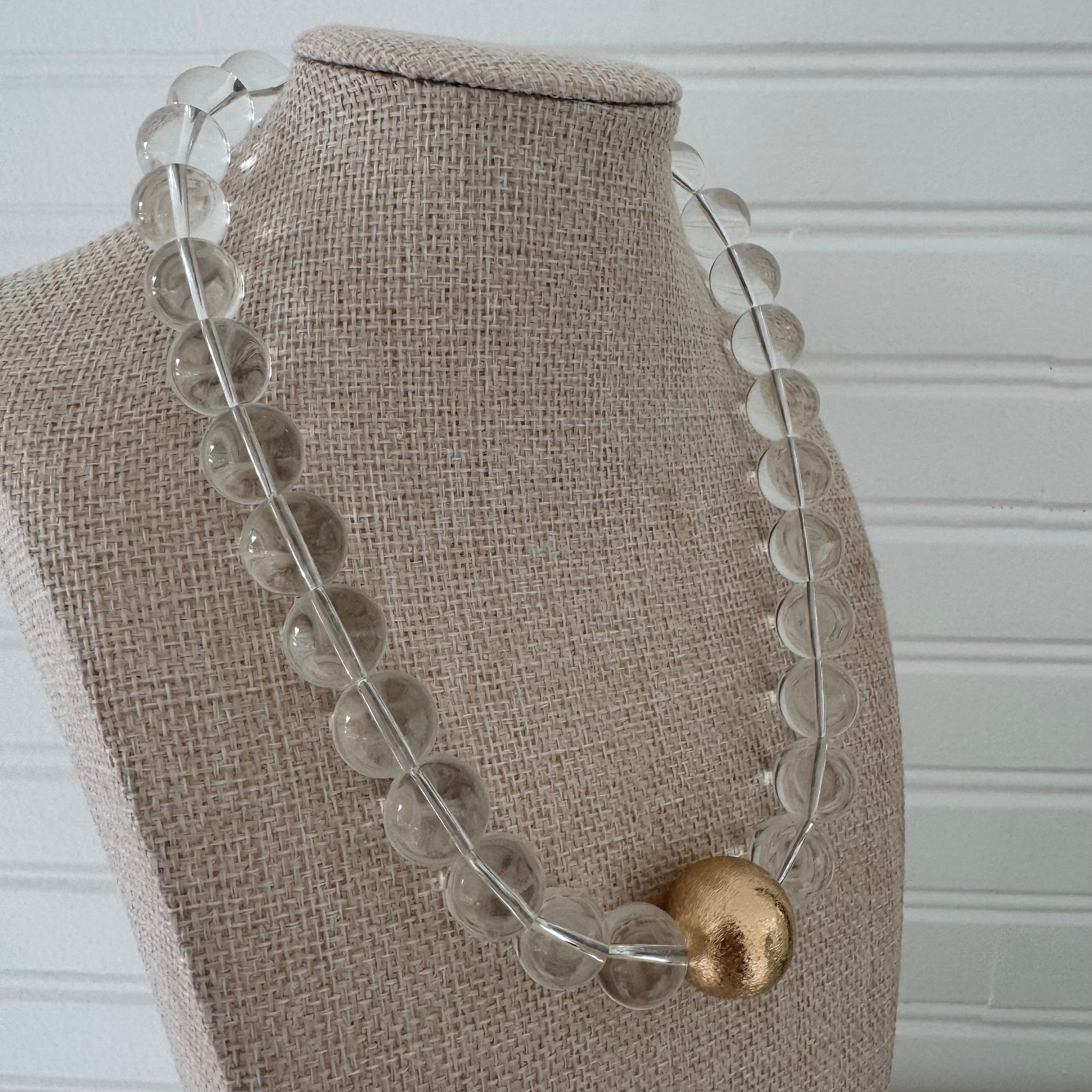 Chunky clear bead statement necklace with a large gold center bead.