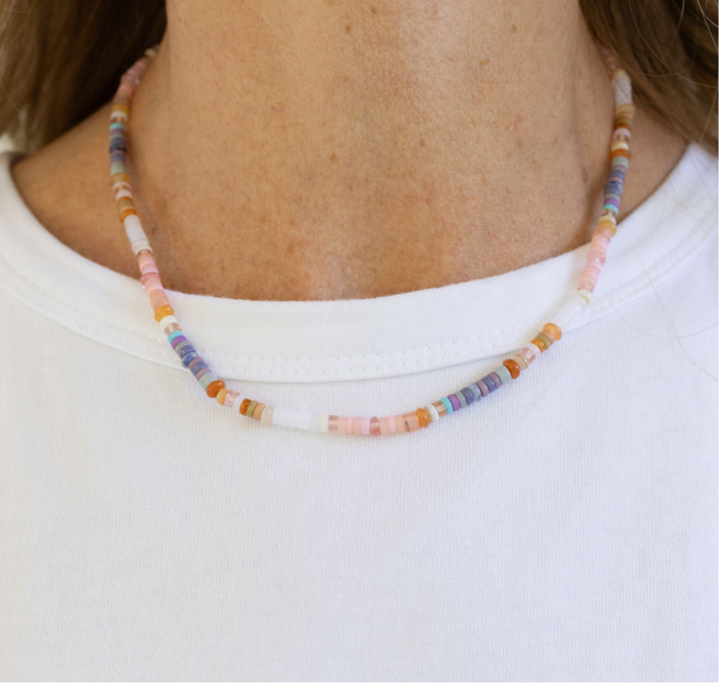 Multicolored beaded necklace worn by a person on a white background