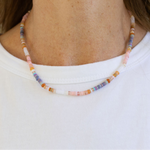 Multicolored beaded necklace worn by a person on a white background