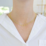 Picture of woman wearing a dainty yellow bead necklace.