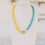 Yellow and turquoise colored beaded necklace with a gold clasp.