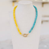 Yellow and turquoise colored beaded necklace with a gold clasp.