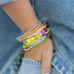 Colorful beaded bracelets on a wrist with denim background