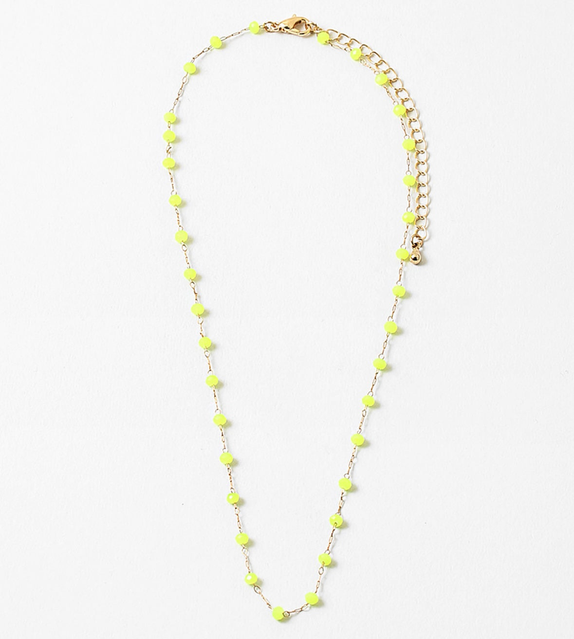 A gold-colored necklace with neon yellow beads and a clasp, displayed against a white background.
