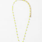 A gold-colored necklace with neon yellow beads and a clasp, displayed against a white background.