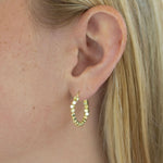 Gold hoop earring worn by a person with blonde hair.