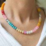 Girl wearing a light multi-colored beaded short necklace around her neck