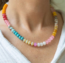Girl wearing a light multi-colored beaded short necklace around her neck