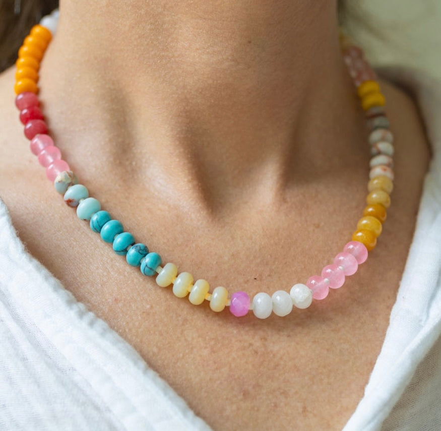 Girl wearing a light multi-colored beaded short necklace around her neck