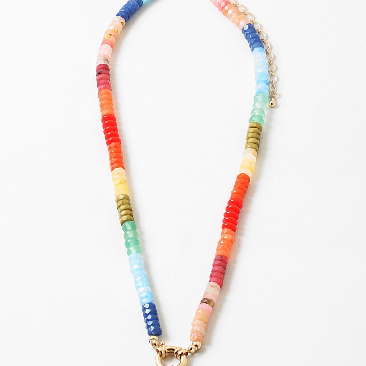 Brightly colored bead necklace with orange, yellow, blues and green beads. Necklace has a large gold clasp at its center.