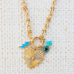 Picture of gold toggle necklace with a large heart pendant with a diamond at the center. Necklace has three charms attached. One a blue lightening bolt, an evil eye and a blue dice.