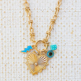 Picture of gold toggle necklace with a large heart pendant with a diamond at the center. Necklace has three charms attached. One a blue lightening bolt, an evil eye and a blue dice.