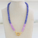 Picture of a blue periwinkle colored bead necklace with a section of light purple beads and a large gold carabiner clasp.