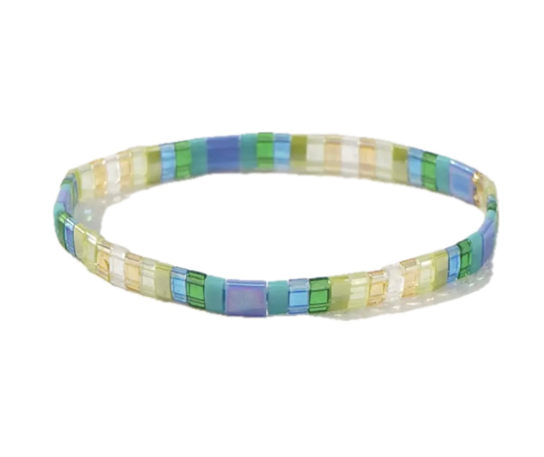 Blue, green and cream multicolored rectangle beaded bracelet on a white background