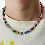 Model wearing a short multicolored beaded necklace.