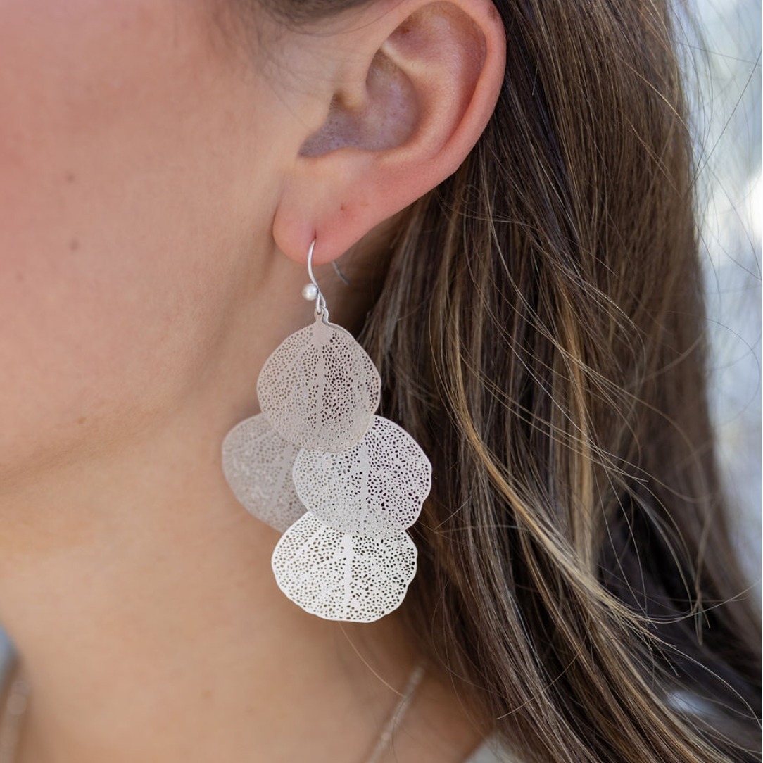 Picture of model wearing a overlapped silver leaf earrings.