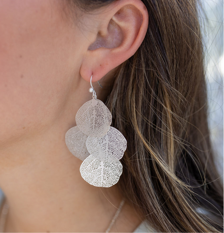 Picture of model wearing a overlapped silver leaf earrings.