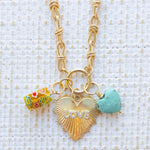 Picture of gold toggle chain with a large gold heart pendant with the word "Love" in diamonds and a yellow flowered charm and blue turquoise heart charm.